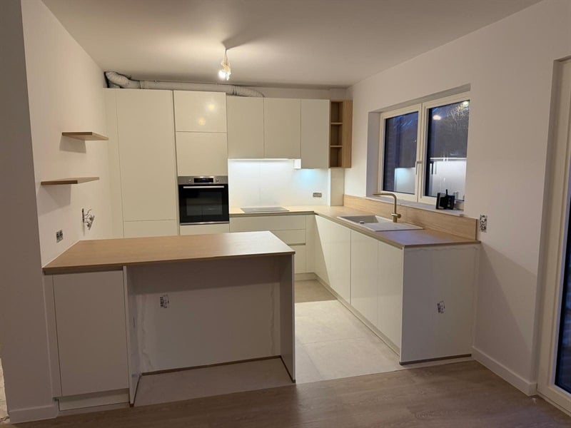 Cuisine ouverte de style moderne bois et blanc à Woluwe Saint Lambert 1