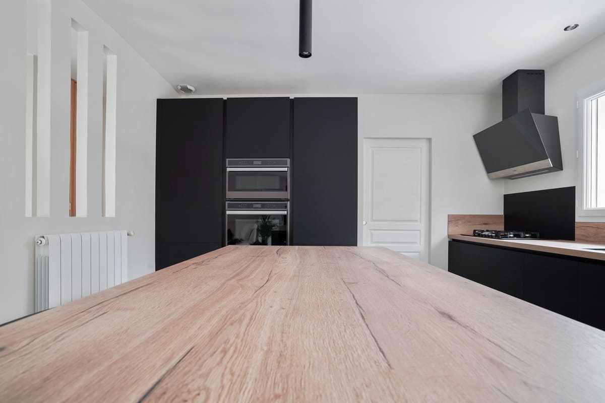 Cuisine noire avec îlot et plan de travail en bois à Blanquefort | Raison Home - 4