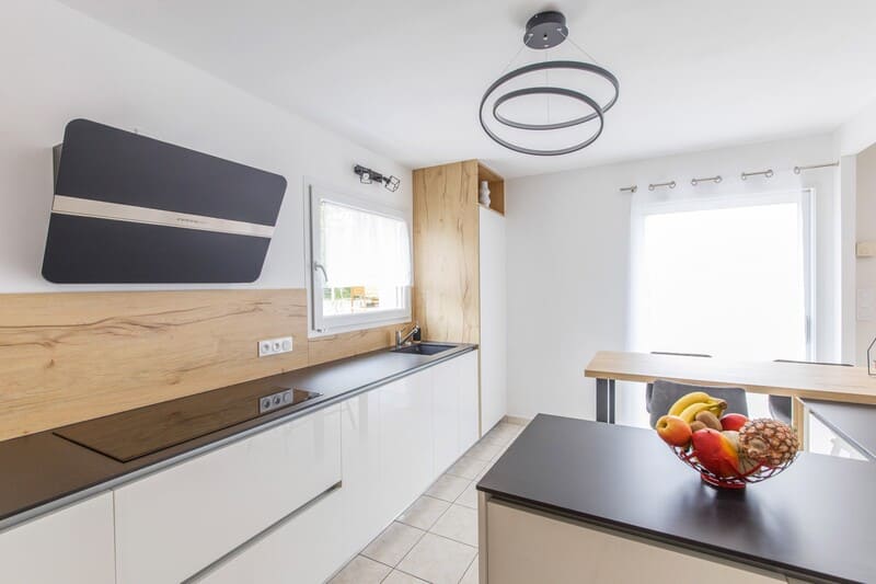 Cuisine blanche et noire avec crédence et façade en bois et îlot central 2