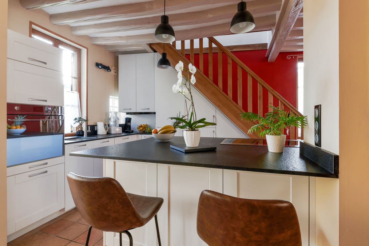 Cuisine ouverte sous escalier blanche et gris foncé à Verneuil-sur-Avre | Raison Home - 1