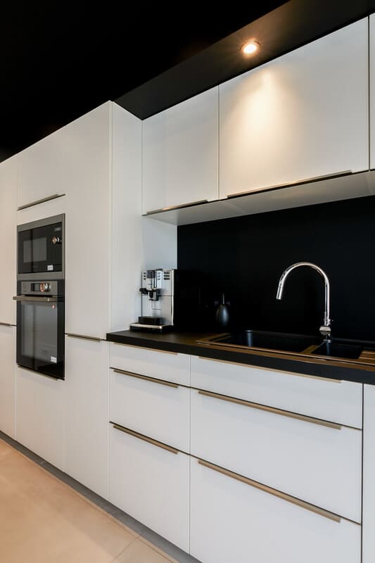 Cuisine ouverte design noire et blanche avec îlot central à Vitré | Raison Home - 5