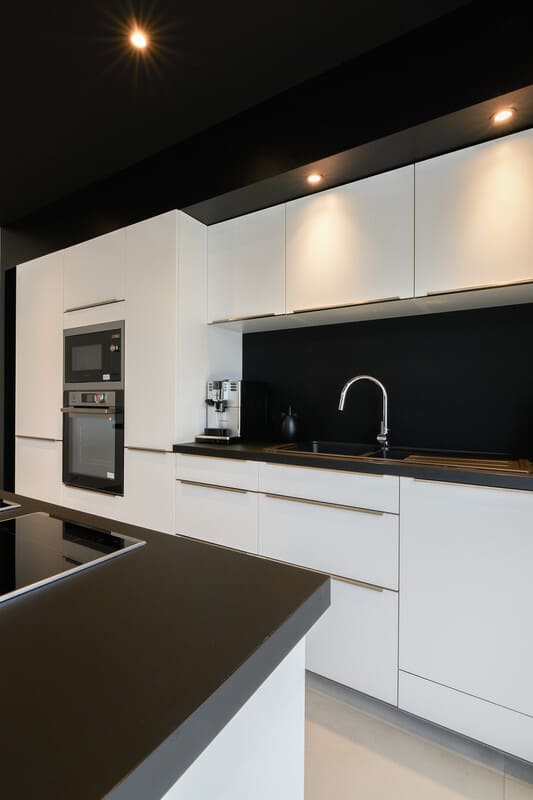 Cuisine ouverte design noire et blanche avec îlot central à Vitré | Raison Home - 7