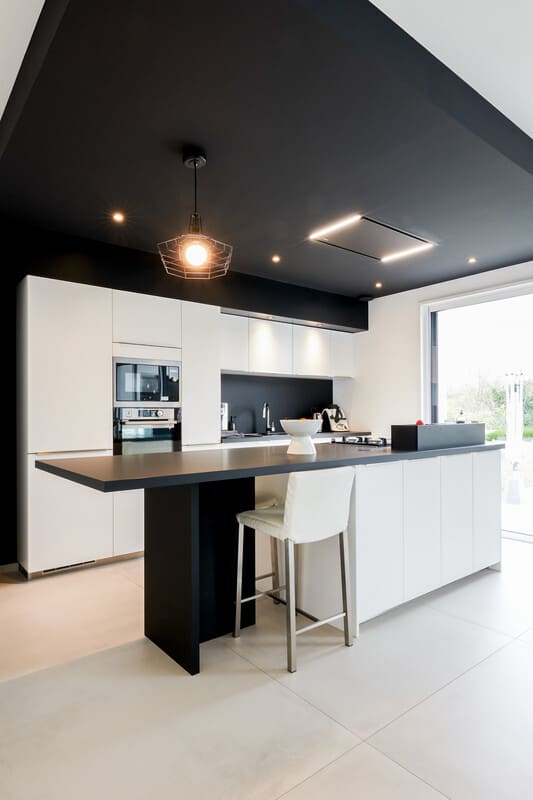 Cuisine ouverte design noire et blanche avec îlot central à Vitré | Raison Home - 2