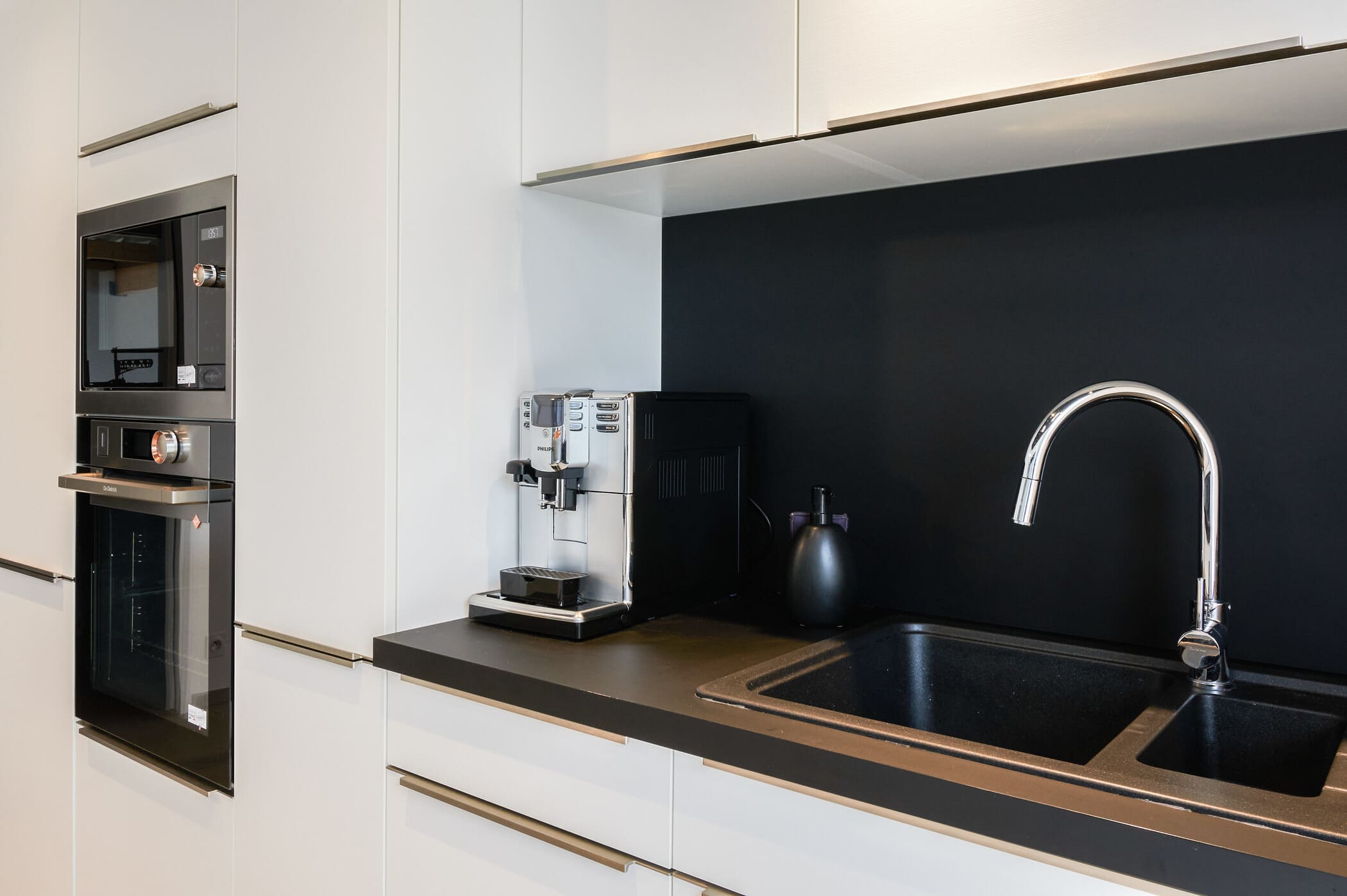 Cuisine ouverte design noire et blanche avec îlot central à Vitré | Raison Home - 10