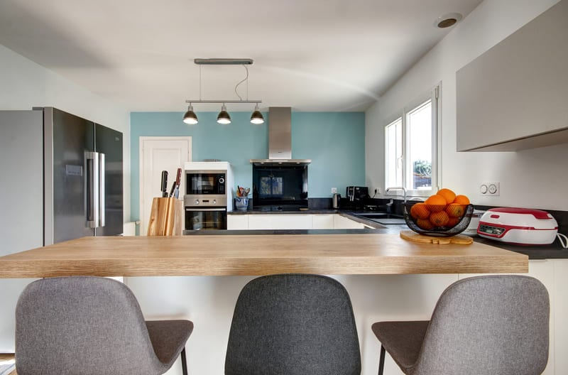 Cuisine ouverte blanche, bois et bleu ciel avec bar à Lanester | Raison Home - 1