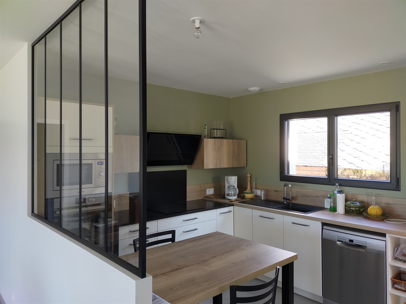 Cuisine ouverte bois et noir avec mur vert olive à Bouvron | Raison Home - 1