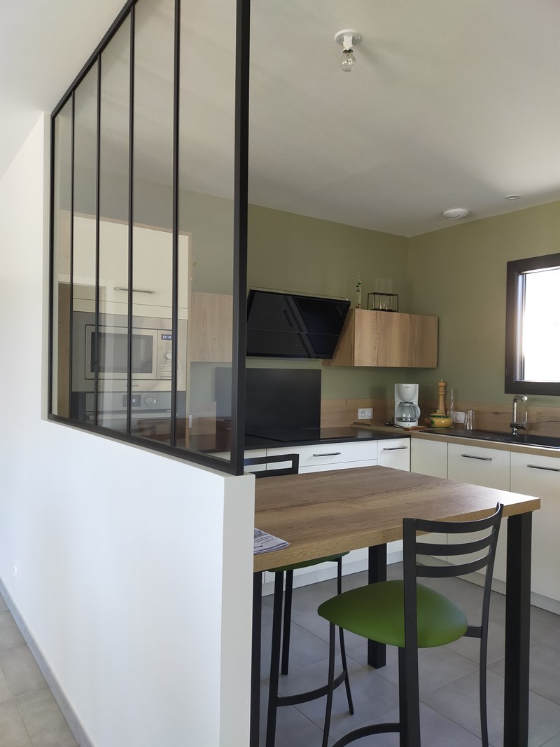 Cuisine ouverte bois et noir avec mur vert olive à Bouvron | Raison Home - 2