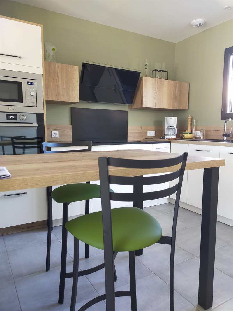 Cuisine ouverte bois et noir avec mur vert olive à Bouvron | Raison Home - 5