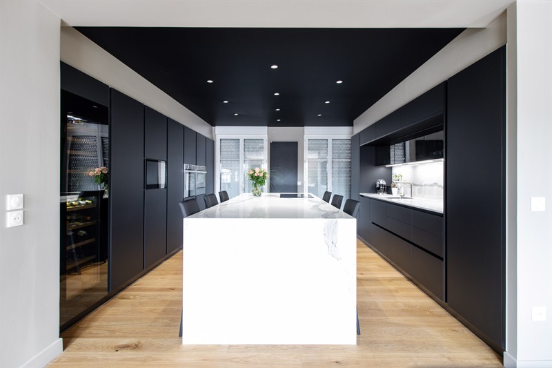 Cuisine en couloir de style moderne noire et blanche à L'Isle-Adam | Raison Home - 1