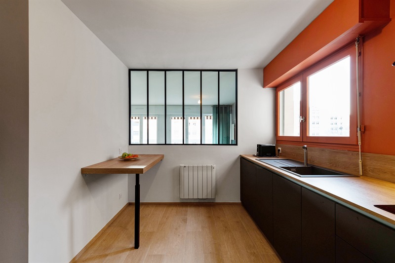 Cuisine moderne gris foncé et bois avec mur orange à Lyon 3