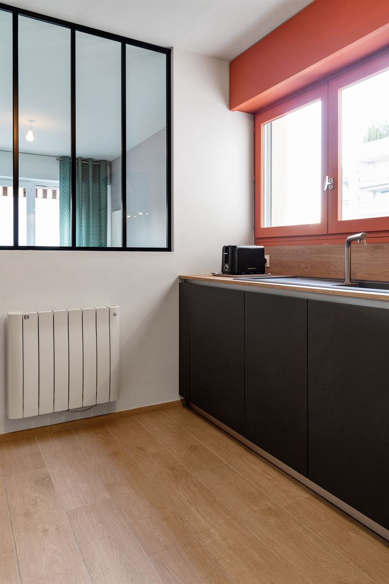 Cuisine moderne gris foncé et bois avec mur orange à Lyon | Raison Home - 6