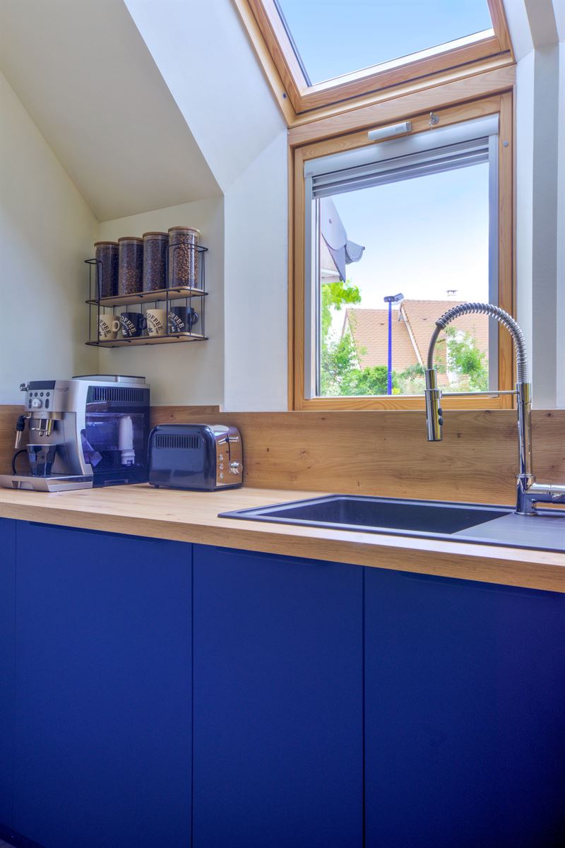 Cuisine ouverte bleu et bois avec mur jaune à Cuverville | Raison Home - 6