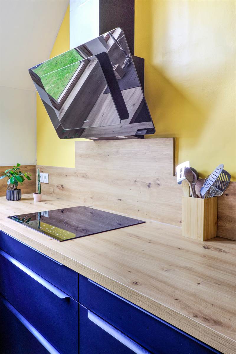 Cuisine ouverte bleu et bois avec mur jaune à Cuverville | Raison Home - 7