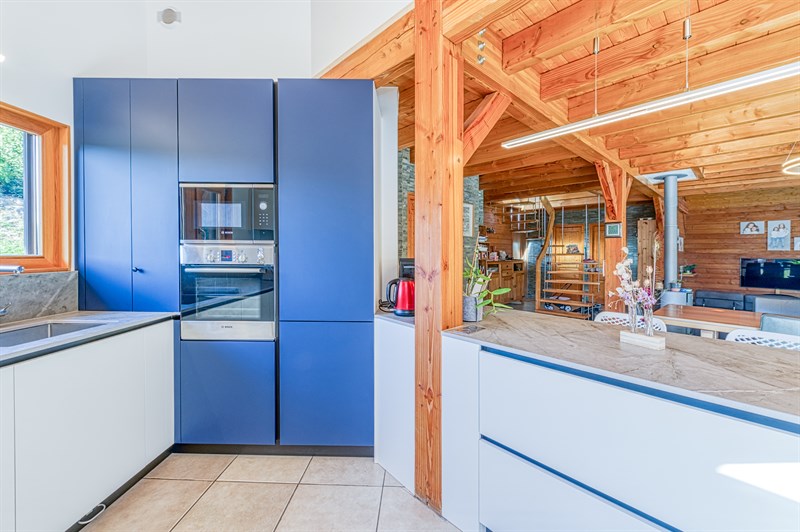 Cuisine moderne blanc et bleu dans un intérieur bois à Les Ollieres 1