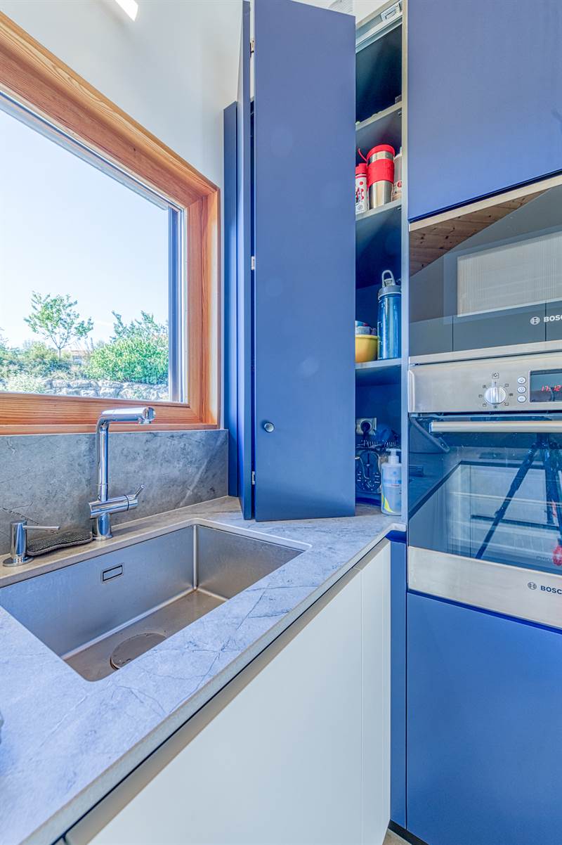 Cuisine moderne blanc et bleu dans un intérieur bois à Les Ollieres 5