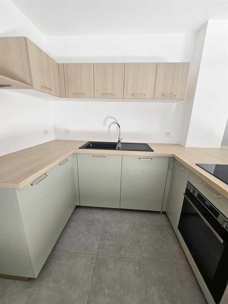 Cuisine ouverte aux tons clairs vert et bois 3