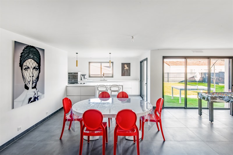 Cuisine blanche avec chaises rouges de style moderne à Nouaillé-Maupertuis 1