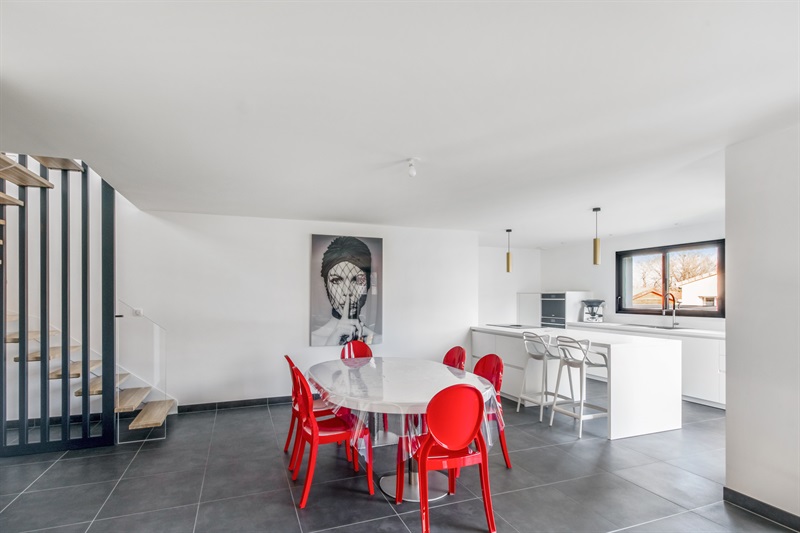 Cuisine blanche avec chaises rouges de style moderne à Nouaillé-Maupertuis | Raison Home - 2