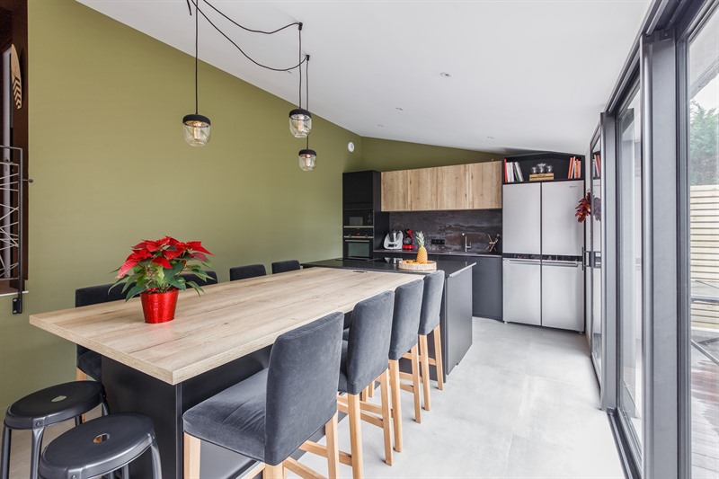 Cuisine moderne avec grand îlot et mur vert olive à Arradon | Raison Home - 2