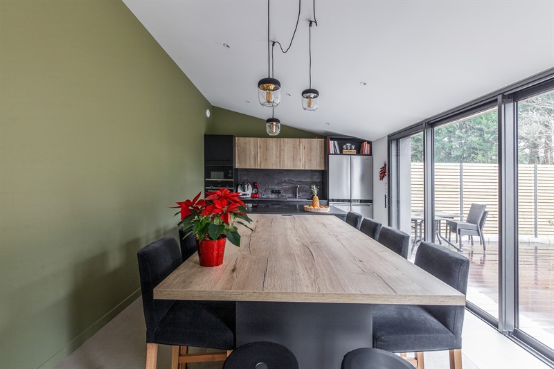 Cuisine moderne avec grand îlot et mur vert olive à Arradon | Raison Home - 8