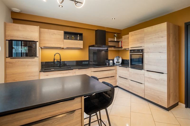 Cuisine moderne de ton bois et noir à Torce 1