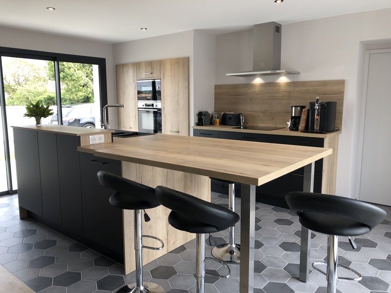 Cuisine contemporaine noir et bois avec îlot central espace repas à Aiffres | Raison Home - 1